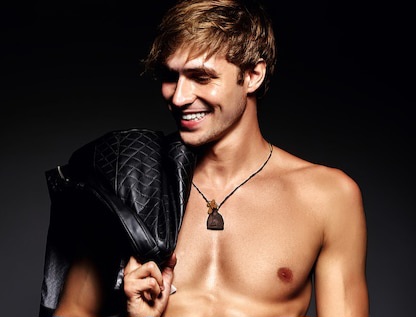 young-handsome-muscled-fit-male-model-man-posing-studio-showing-his-abdominal-muscles-leather-jacket_158538-2252